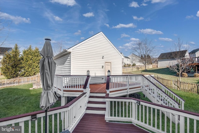 deck featuring a fenced backyard, a lawn, and stairway