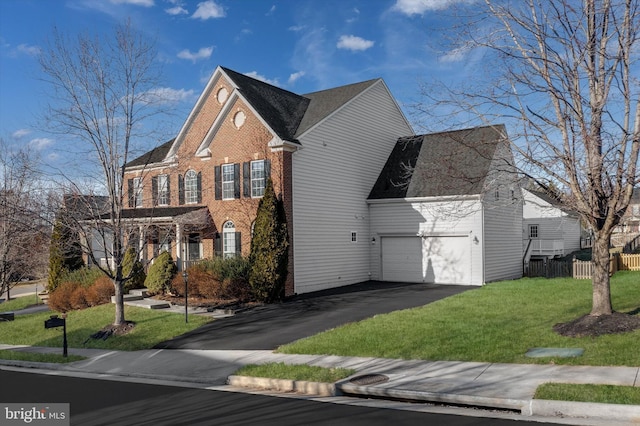 view of front of home with an attached garage, brick siding, fence, driveway, and a front lawn