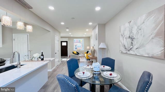 dining space with light wood-style flooring, baseboards, and recessed lighting