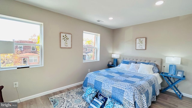 bedroom with recessed lighting, wood finished floors, visible vents, and baseboards