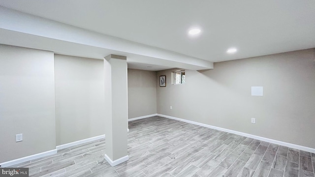 finished below grade area with light wood-style floors, recessed lighting, and baseboards