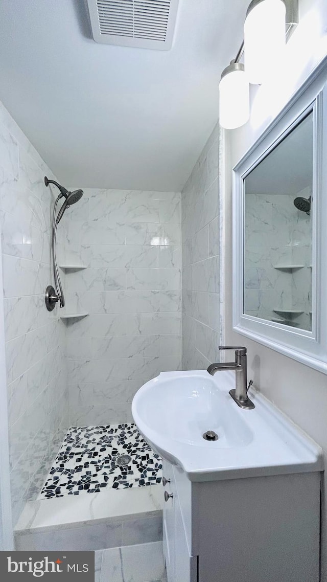 bathroom with a stall shower, visible vents, and vanity