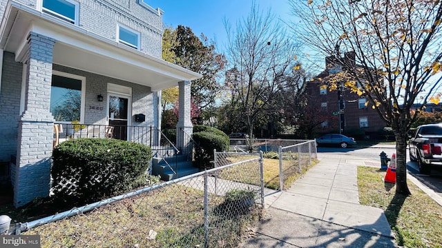 view of yard with covered porch and fence