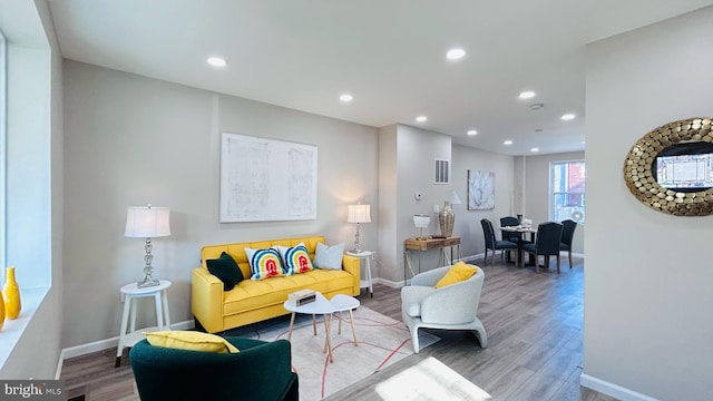 living room with recessed lighting, baseboards, and wood finished floors