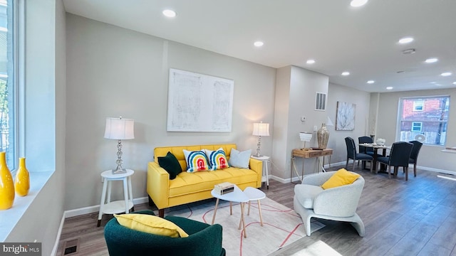 living room with baseboards, wood finished floors, and recessed lighting