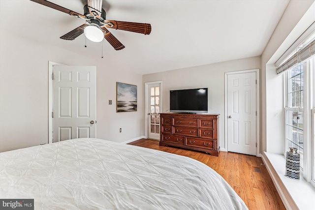 bedroom featuring baseboards, wood finished floors, and a ceiling fan