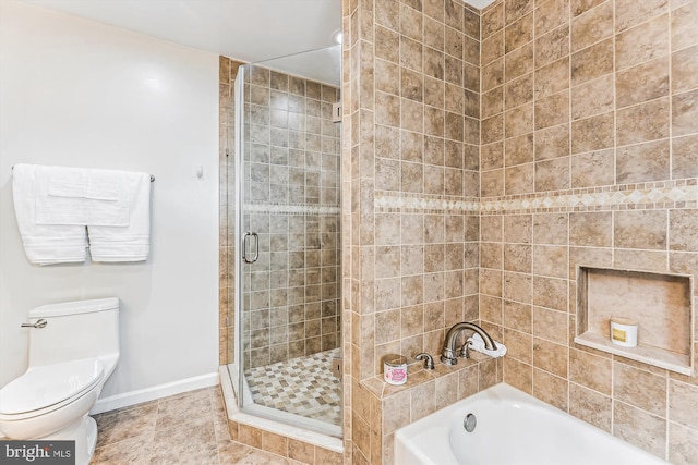 bathroom featuring baseboards, a stall shower, tile patterned flooring, a garden tub, and toilet