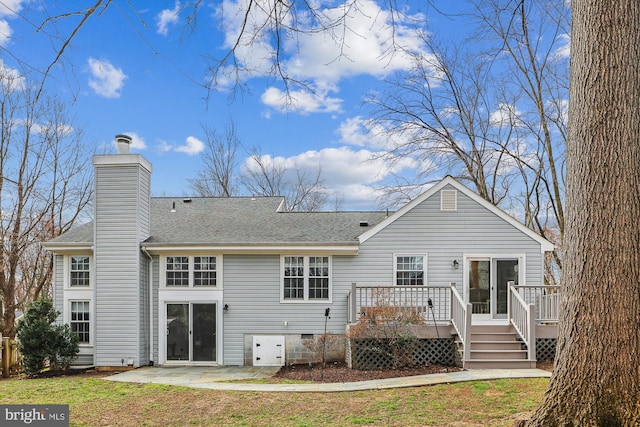 rear view of property with a deck, a patio, a shingled roof, crawl space, and a chimney