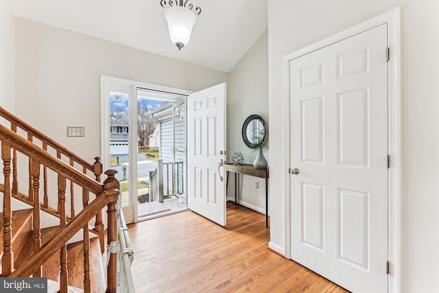 foyer featuring stairs, light wood-type flooring, and baseboards