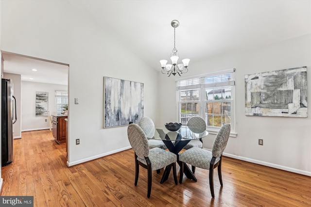 dining room with baseboards, plenty of natural light, a chandelier, and light wood finished floors