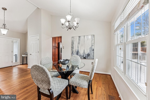 dining area featuring a chandelier, visible vents, baseboards, and light wood-style floors