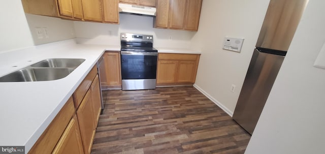 kitchen featuring light countertops, a sink, under cabinet range hood, and stainless steel electric range