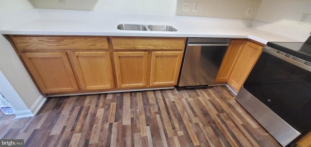 kitchen with appliances with stainless steel finishes, light countertops, and dark wood-style floors