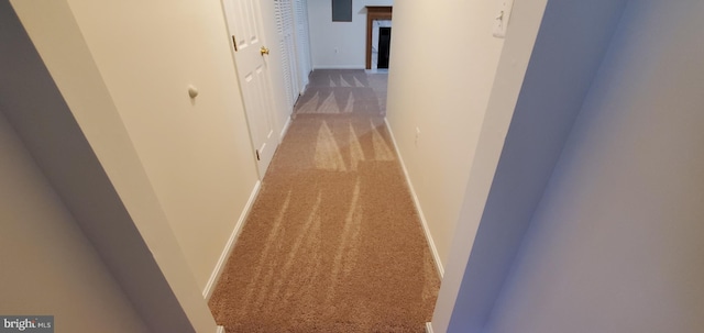 hallway with light colored carpet and baseboards