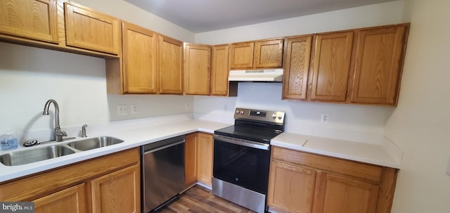 kitchen with stainless steel appliances, light countertops, a sink, and under cabinet range hood