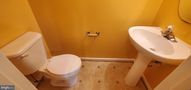 bathroom featuring baseboards and toilet