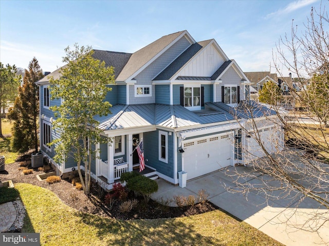 view of front of property featuring central air condition unit, driveway, a standing seam roof, a porch, and metal roof