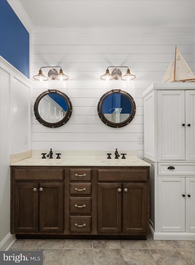 bathroom with a sink, double vanity, and crown molding