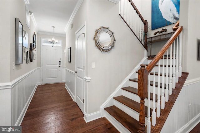 stairway with an inviting chandelier, wood finished floors, wainscoting, and ornamental molding