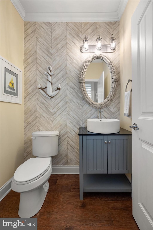 bathroom featuring baseboards, vanity, wood finished floors, and crown molding