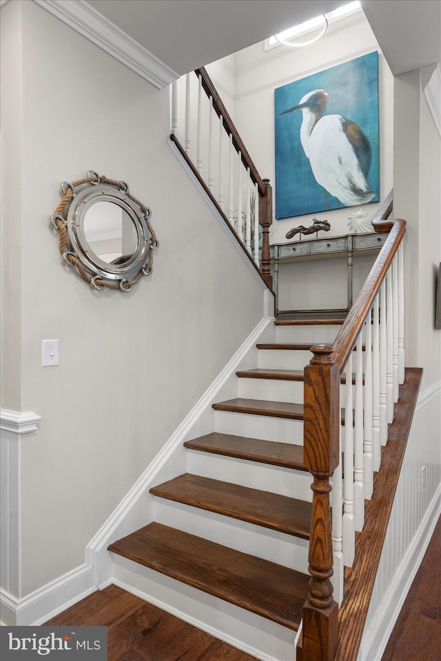 stairs with crown molding, baseboards, and wood finished floors