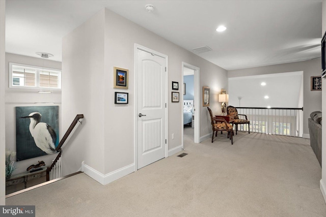 sitting room with an upstairs landing, baseboards, and carpet floors