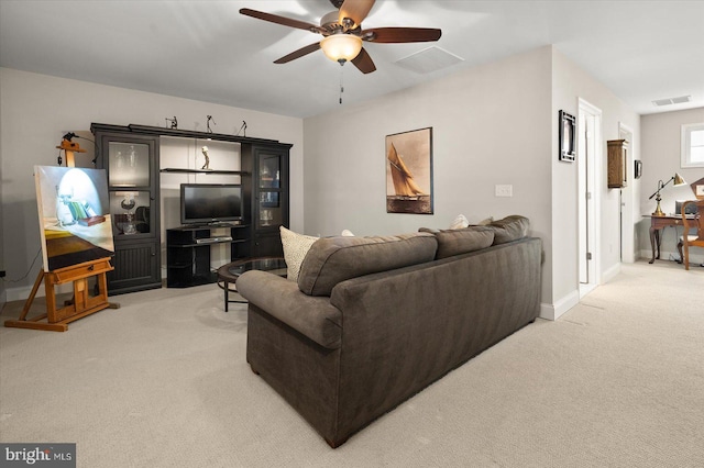 living room with light carpet, visible vents, baseboards, and ceiling fan