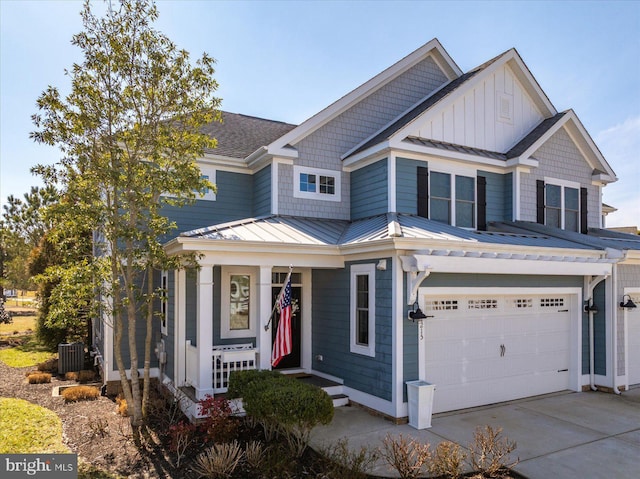 view of front of property featuring cooling unit, driveway, a standing seam roof, a garage, and metal roof