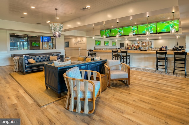 living room with recessed lighting, a notable chandelier, wood finished floors, and visible vents