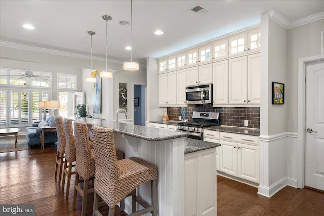 kitchen with crown molding, visible vents, appliances with stainless steel finishes, and dark wood-type flooring