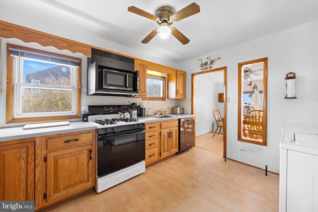 kitchen with black microwave, a sink, dishwasher, gas stove, and washer / dryer