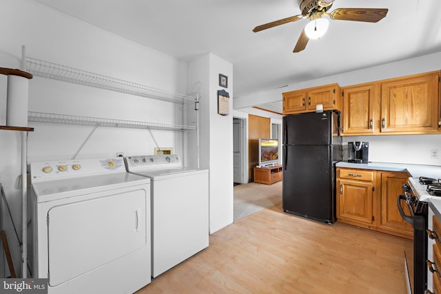 washroom featuring laundry area, ceiling fan, washer and clothes dryer, and light wood finished floors