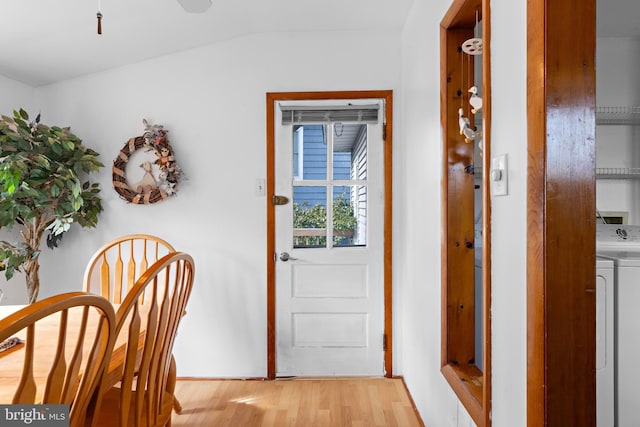 doorway to outside with washer / dryer and light wood-style flooring