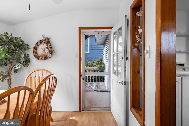 doorway featuring vaulted ceiling, light wood finished floors, and washer / clothes dryer