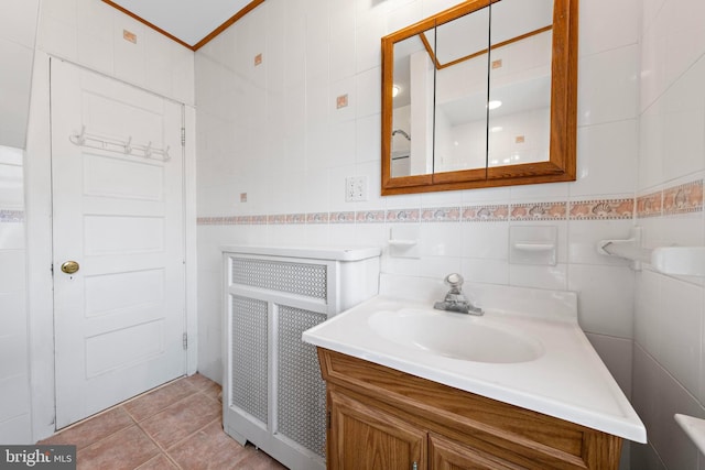 bathroom featuring radiator, tile patterned flooring, tile walls, and vanity