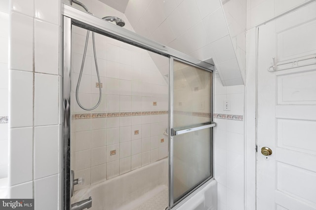 bathroom with bath / shower combo with glass door