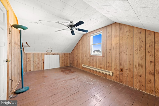 bonus room with vaulted ceiling, wood walls, baseboard heating, and hardwood / wood-style flooring