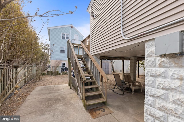 view of patio / terrace featuring stairs and fence