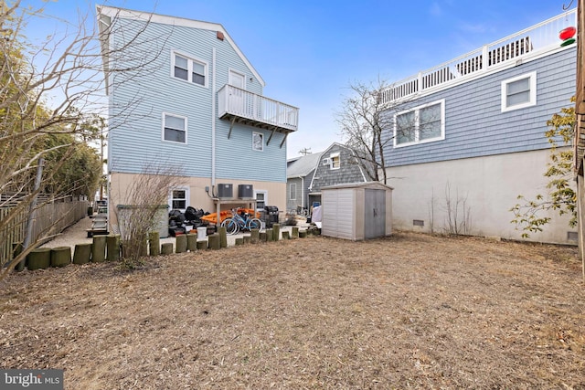 rear view of property featuring a storage shed, stucco siding, and an outdoor structure