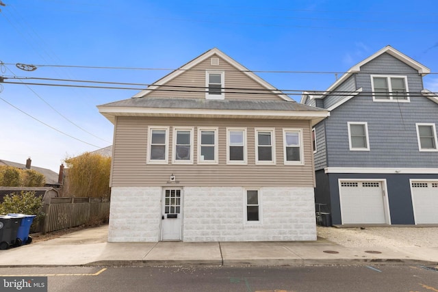 view of front of property with a garage and fence