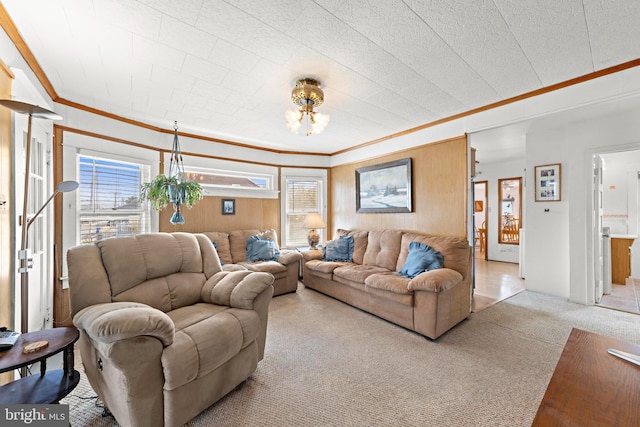 living area featuring an inviting chandelier, crown molding, a wealth of natural light, and carpet flooring