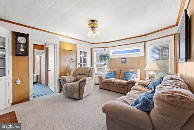 living room featuring carpet floors, wood walls, radiator, and crown molding