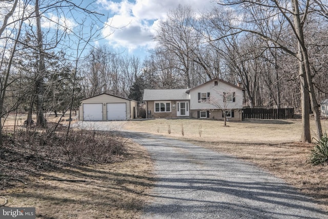 tri-level home with a garage and an outbuilding