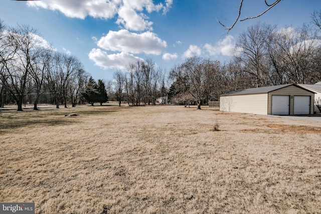 view of yard featuring a garage and an outbuilding