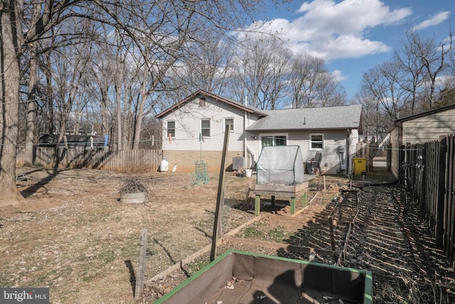 back of property with central AC unit, roof with shingles, and fence private yard