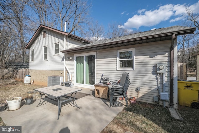 rear view of house with a patio area, fence, and central AC