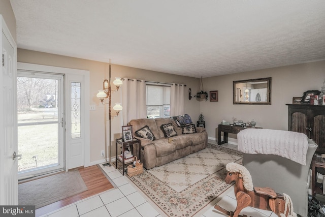 living area with light tile patterned floors, plenty of natural light, and baseboards