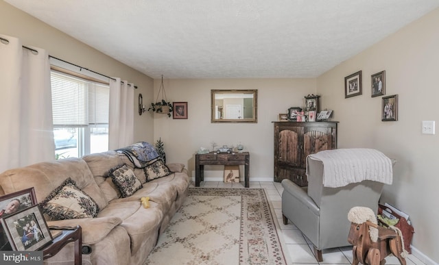 living room featuring light tile patterned floors, a textured ceiling, and baseboards