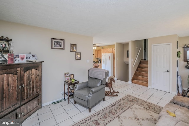 living room featuring light tile patterned floors, ceiling fan, stairs, and baseboards