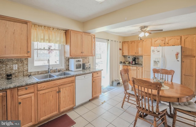 kitchen featuring white appliances, plenty of natural light, tasteful backsplash, and a sink